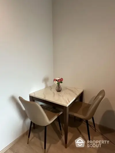 Cozy dining nook with a marble-top table and two elegant chairs, perfect for intimate meals or morning coffee.