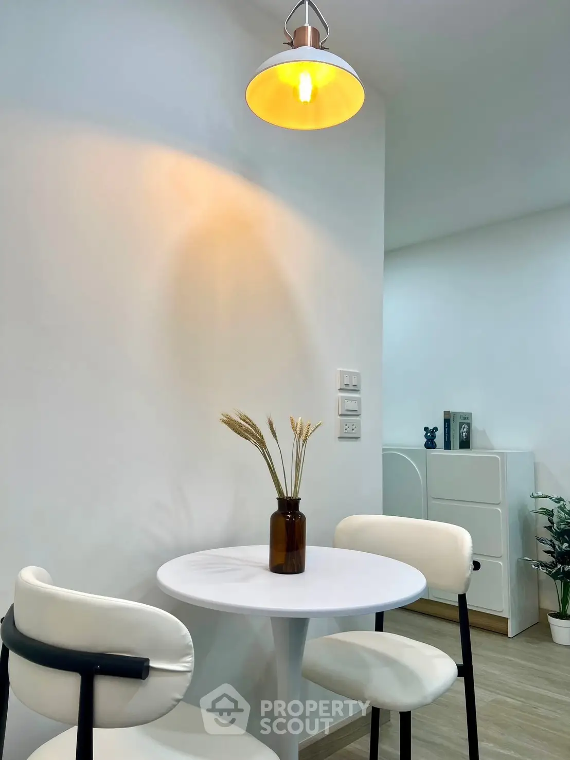 Modern dining nook with round table and stylish chairs in a cozy apartment setting.