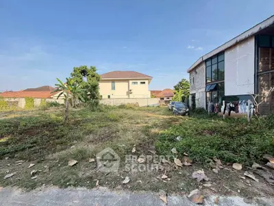 Spacious vacant land with potential for development, surrounded by residential buildings in a serene neighborhood.