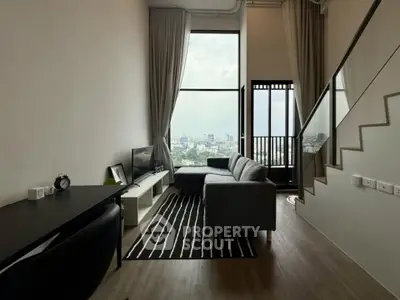 Modern living room with city view, featuring sleek furniture and large windows for natural light.