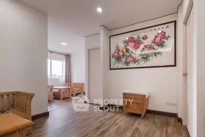 Spacious living room with elegant wooden furniture and floral wall art