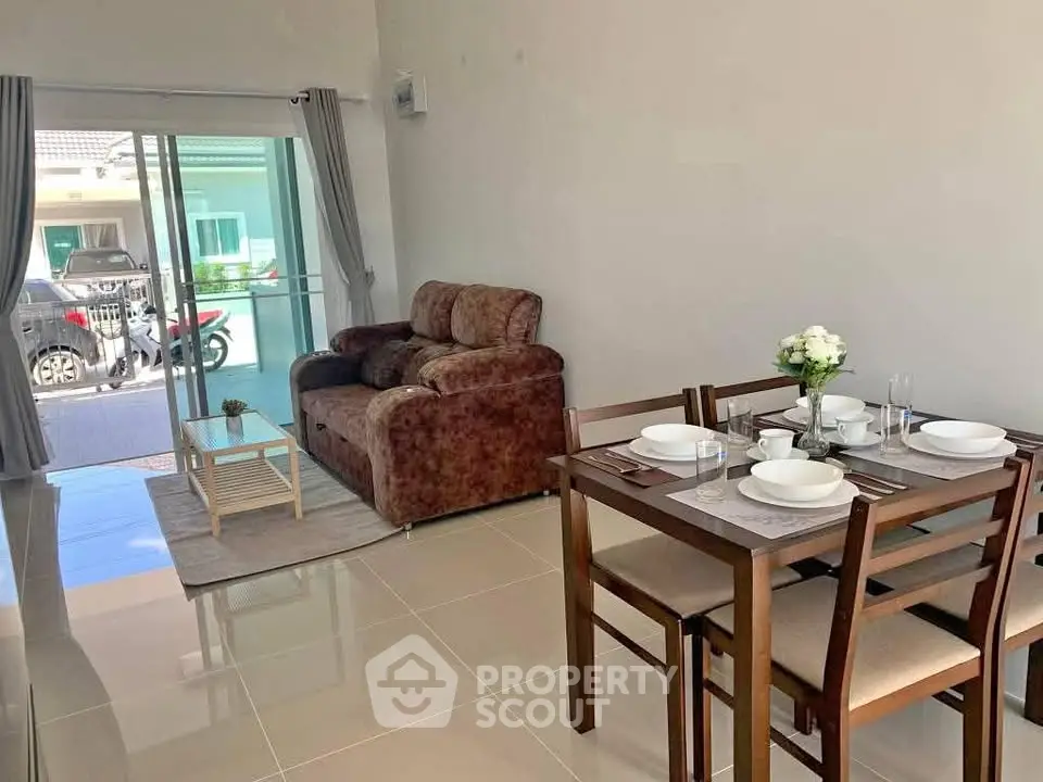 Modern living and dining area with sliding glass doors and cozy furniture.