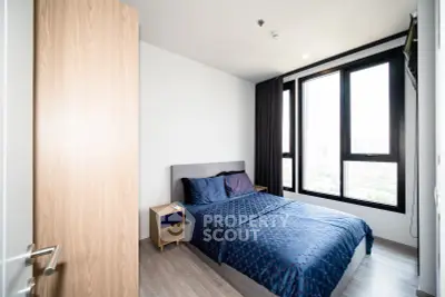 Modern bedroom with large windows and stylish decor in a high-rise apartment.
