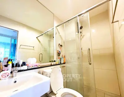 Modern bathroom with glass shower and sleek fixtures in a contemporary home.
