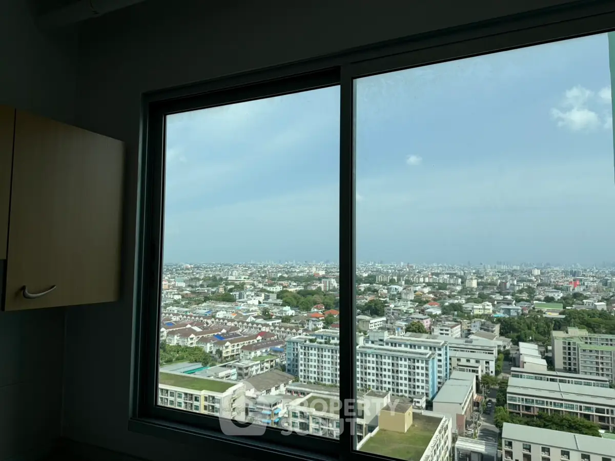 Stunning cityscape view from high-rise apartment window, showcasing urban living at its finest.