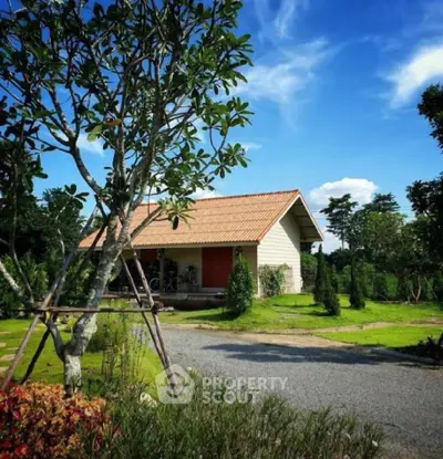Charming countryside house with lush garden and clear blue sky