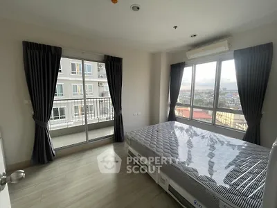 Spacious bedroom with large windows and city view in modern apartment