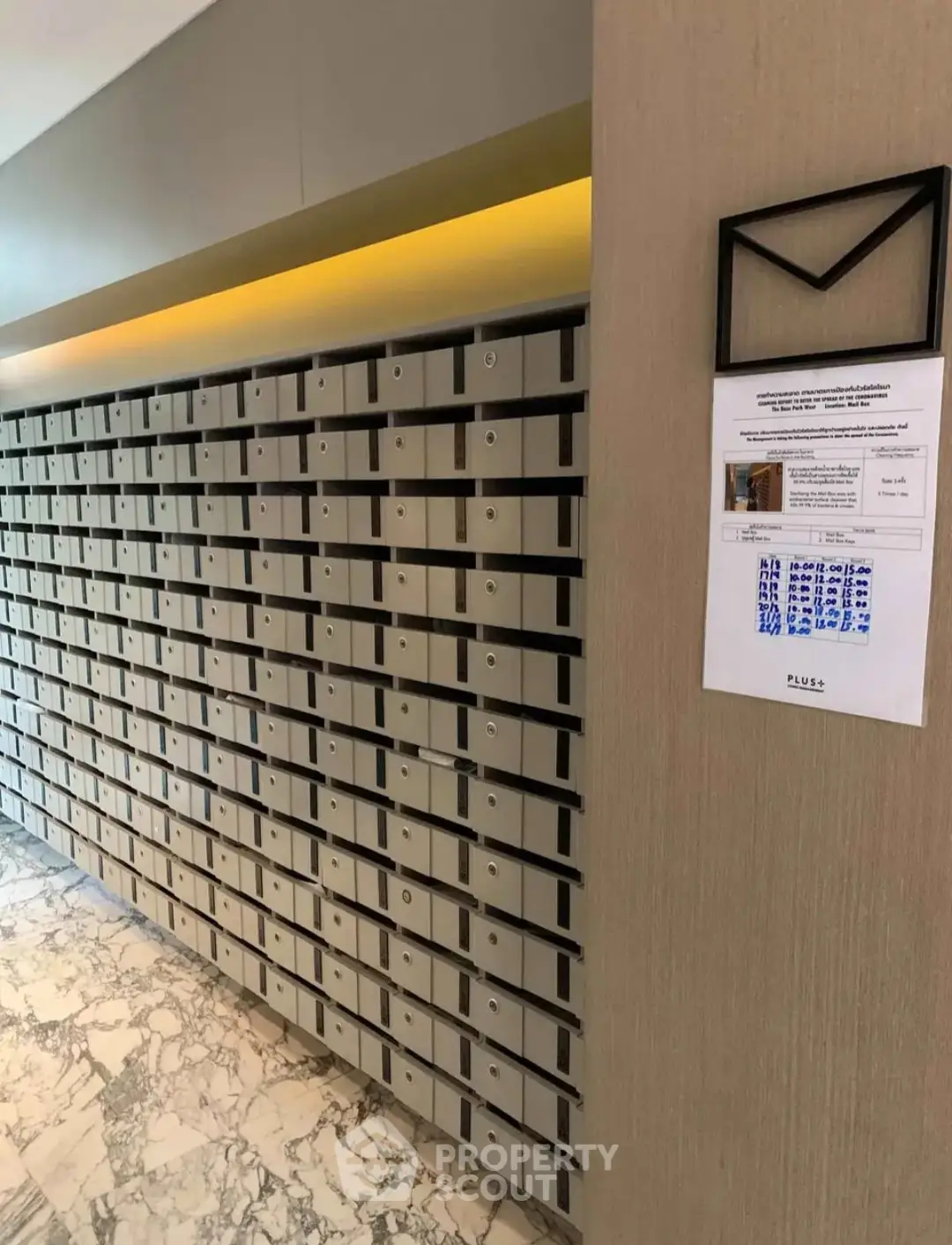 Modern apartment building mailboxes with marble flooring and sleek design.