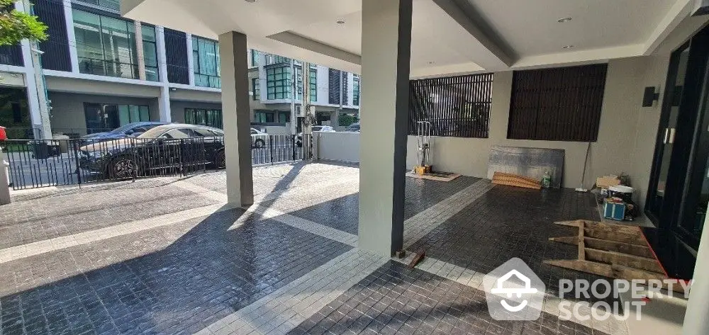 Spacious covered parking area in a modern residential building, featuring clean lines and a well-maintained surface, ideal for urban living.