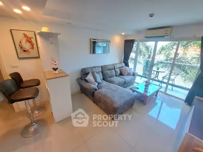 Modern living room with plush sofa, stylish decor, and balcony view in a contemporary apartment.