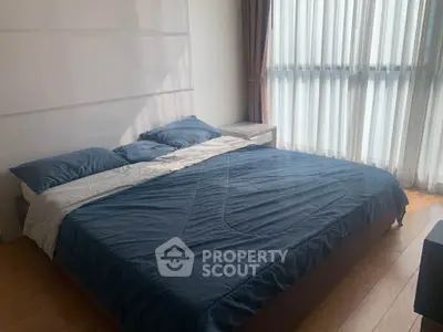 Spacious bedroom with large window and modern decor