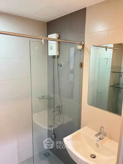 Modern bathroom with glass shower enclosure and sleek white sink
