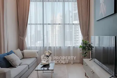 Luxurious living room with stunning city view, modern decor, and large windows for natural light.