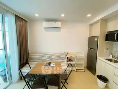 Modern kitchen and dining area with sleek appliances and cozy seating in a stylish apartment.