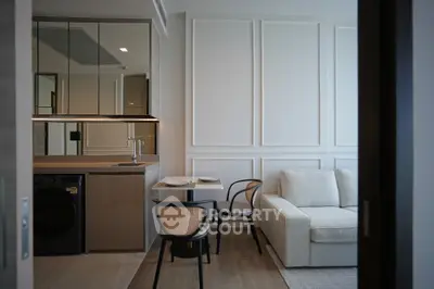 Modern living room with sleek kitchen and cozy dining area in elegant apartment