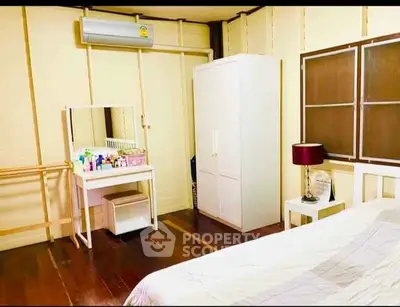 Cozy bedroom with wooden flooring and modern furniture in a well-lit space.