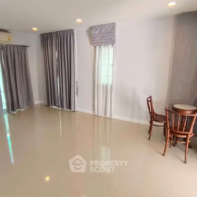 Spacious living room with elegant curtains and cozy dining area