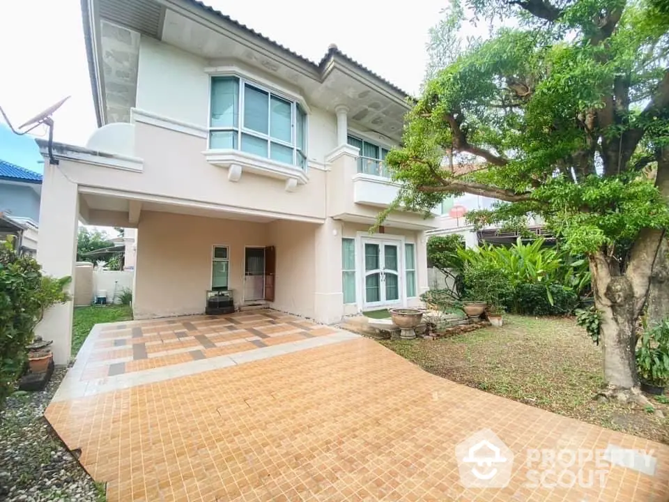 Charming two-story house with spacious driveway and lush garden, perfect for family living.