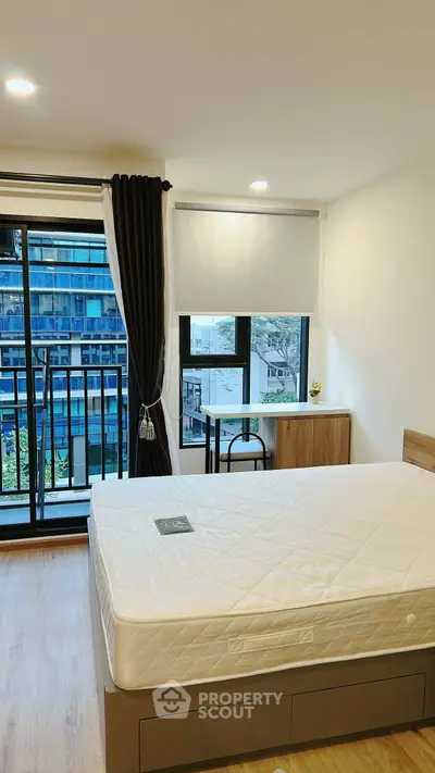 Modern bedroom with large window and balcony view in urban apartment