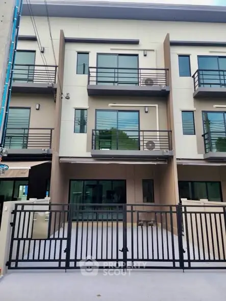 Modern three-story townhouse with sleek design and gated entrance