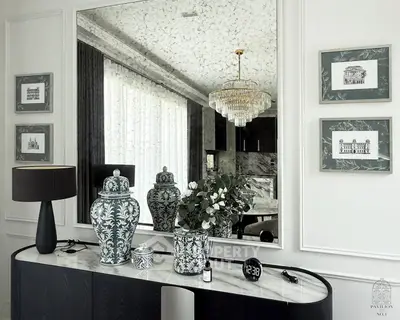 Elegant interior with large mirror, decorative vases, and chandelier in luxury living space