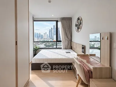 Modern bedroom with city view, featuring sleek furniture and large window.