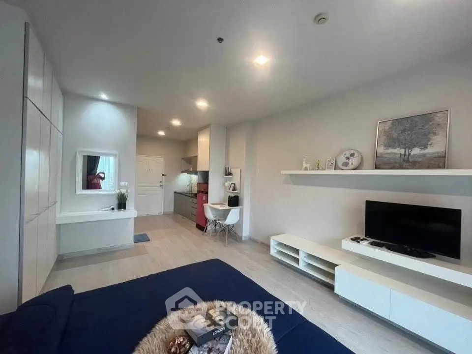 Modern living room with sleek furniture and open kitchen layout in a stylish apartment.