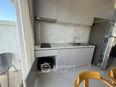 Modern kitchen with sleek cabinets and marble backsplash in a bright apartment