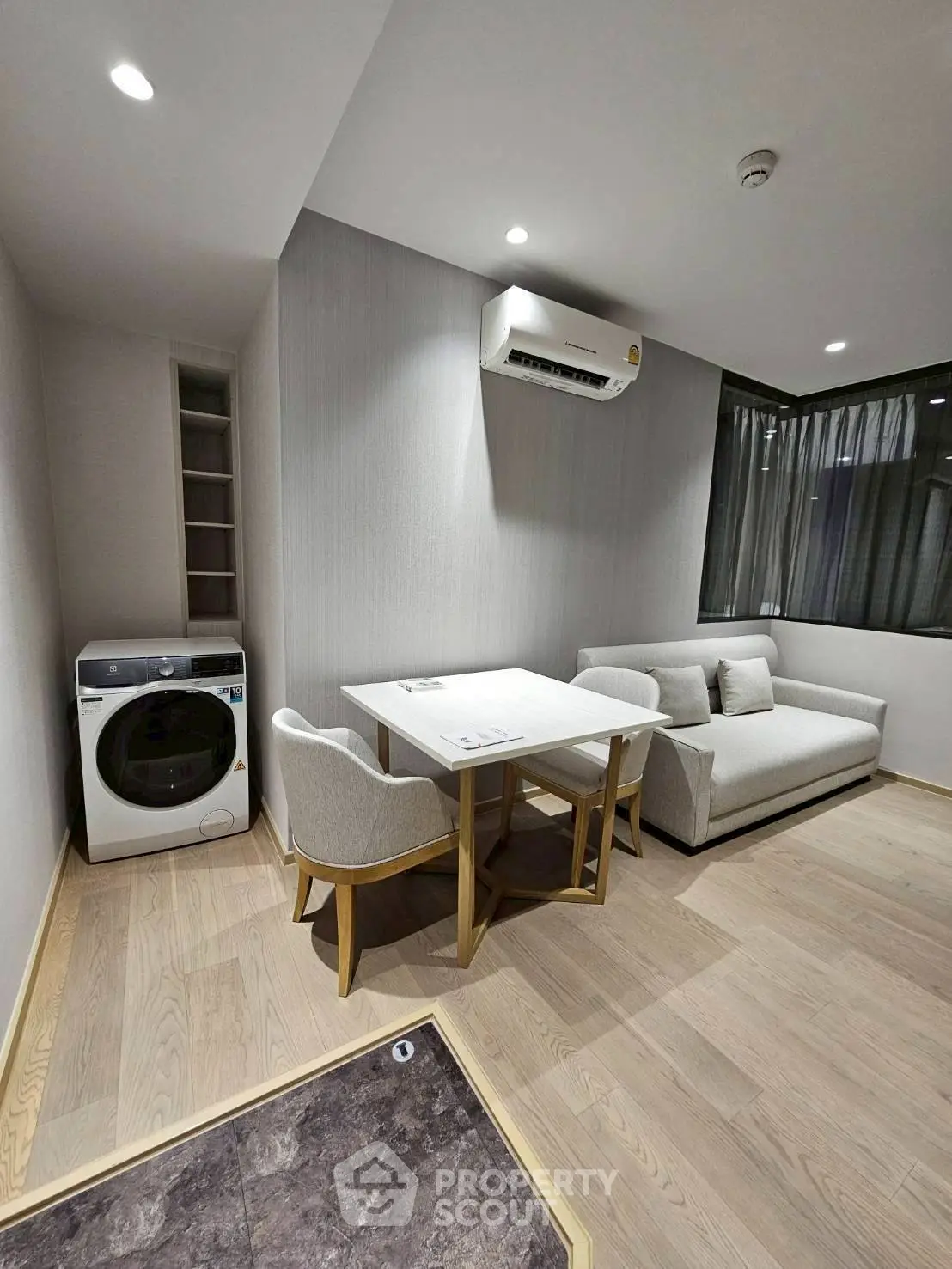 Modern living room with sleek furniture and in-unit washing machine