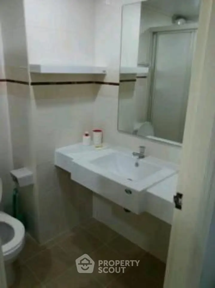 Compact bathroom with modern sink and mirror, featuring a clean and minimalist design.