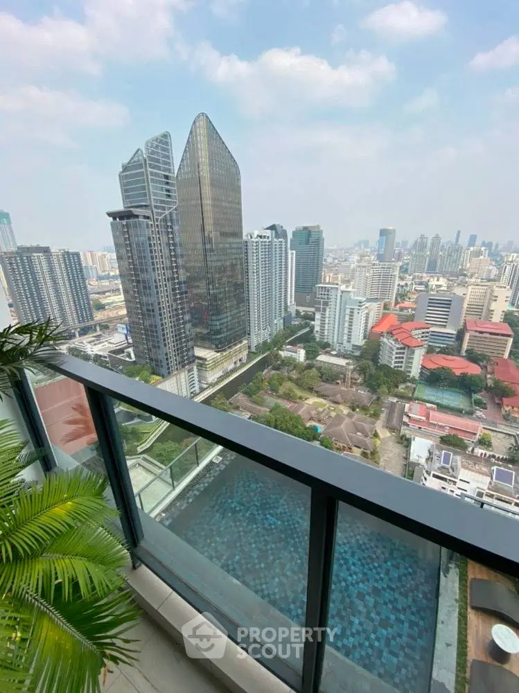 Stunning cityscape view from a high-rise balcony overlooking modern skyscrapers and a serene pool below.
