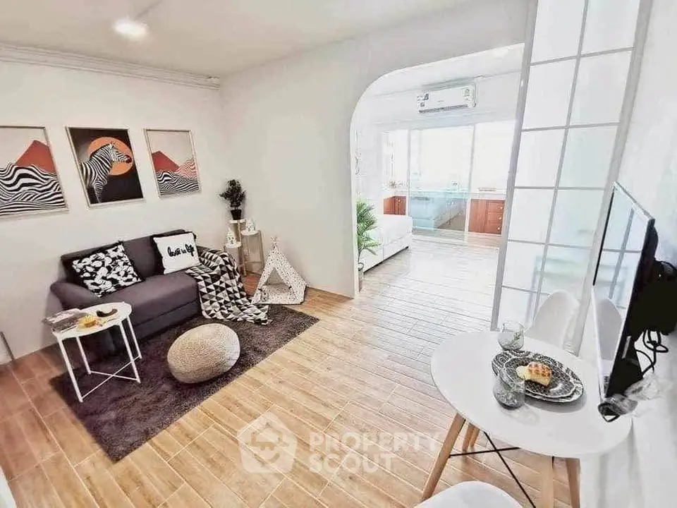 Stylish modern living room with cozy decor and open layout to bedroom.