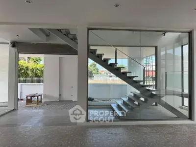 Modern open-concept interior with glass staircase and spacious design