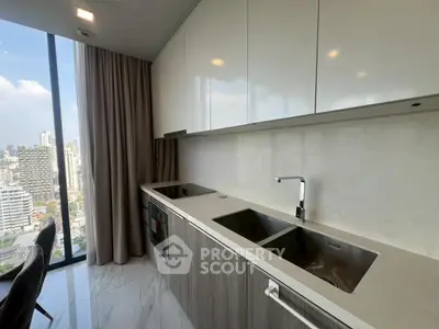 Modern kitchen with sleek cabinetry and stunning city view from large window.