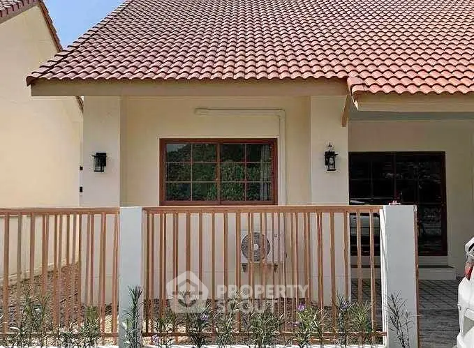 Charming single-story home with red tile roof and fenced front yard, perfect for cozy living.