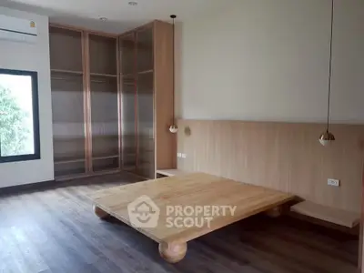 Spacious modern bedroom with wooden flooring and built-in wardrobe