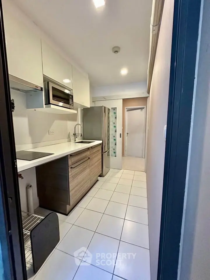 Modern kitchen with sleek cabinetry and stainless steel appliances in a compact layout.