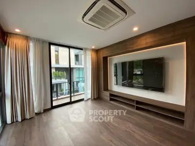 Modern living room with large windows and built-in TV unit