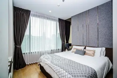 Luxurious bedroom with elegant decor and large window offering natural light