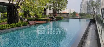 Luxurious rooftop pool with city skyline view and lush greenery, perfect for relaxation and leisure.