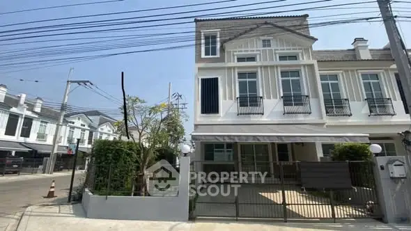 Charming townhouse with gated entrance and lush greenery in a serene neighborhood.