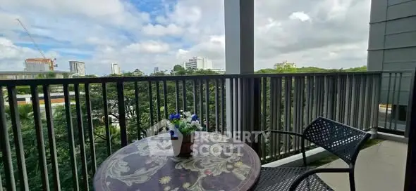 Charming balcony with city view and cozy seating area, perfect for relaxation.