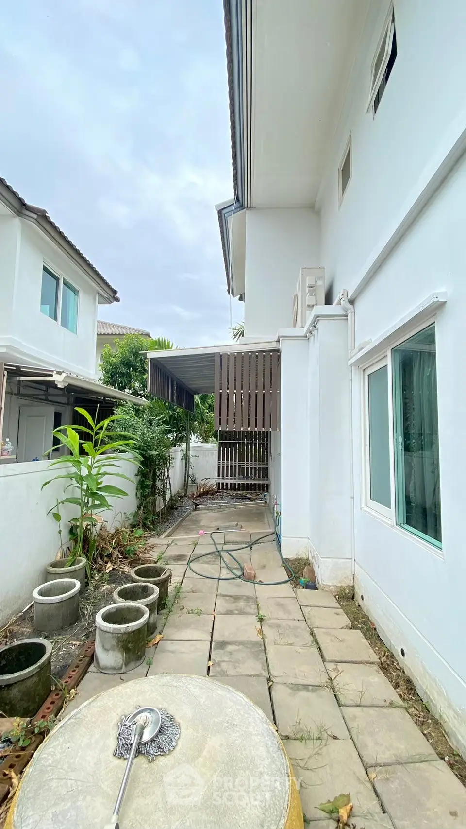 Charming exterior side view of a modern white house with garden potential.