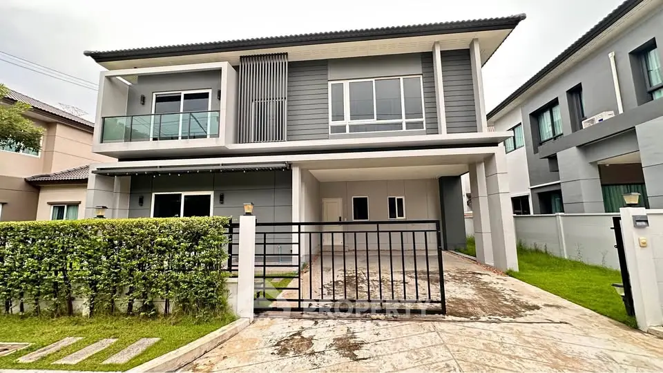 Modern two-story house with sleek design and spacious driveway in a suburban neighborhood.