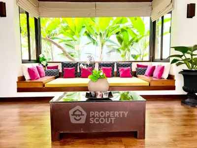 Elegant living room with vibrant cushions and lush garden view