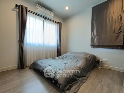 Cozy bedroom with modern decor and natural light, featuring a comfortable bed and stylish curtains.