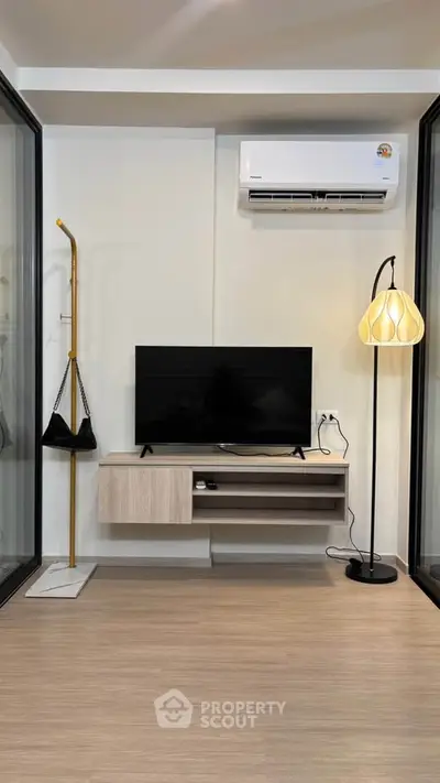 Modern living room with sleek TV setup and stylish floor lamp