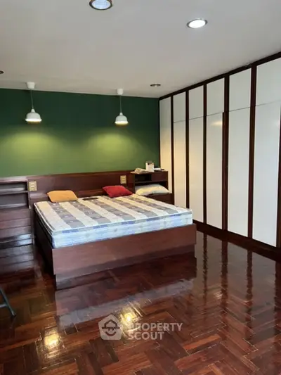 Spacious bedroom with wooden flooring and built-in wardrobe