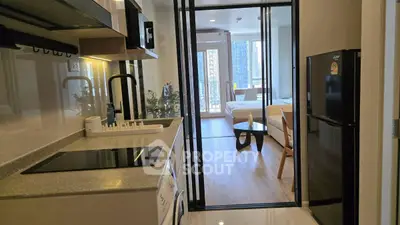 Modern apartment kitchen with sleek appliances and open view to living area