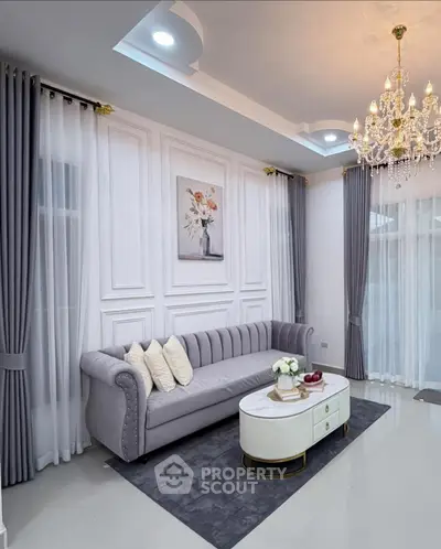 Elegant living room with plush sofa, chandelier, and modern decor